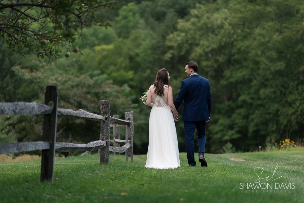 Bride and Groom walking in field at Grafton Inn wedding photo