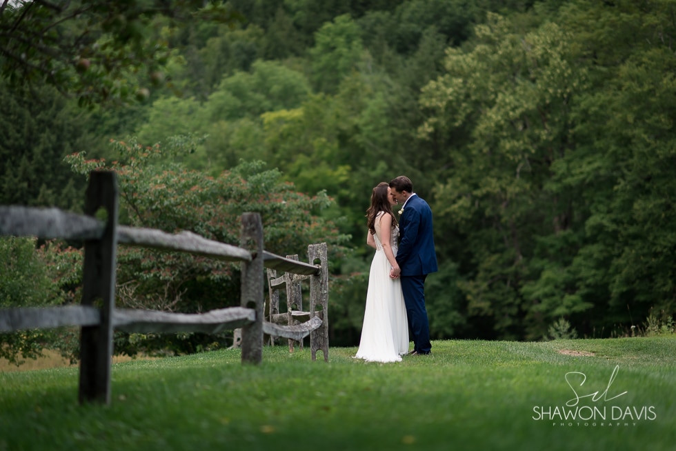 Bride and Groom kissing in field at Grafton Inn wedding photo
