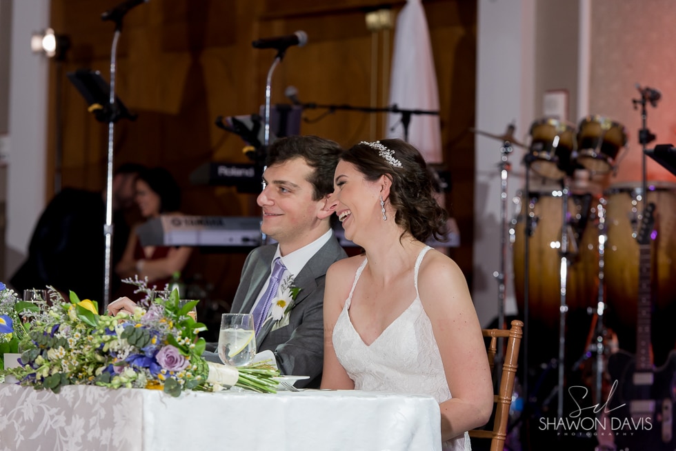 bride and groom laughing during speeches at hyatt regency cambridge hotel wedding 